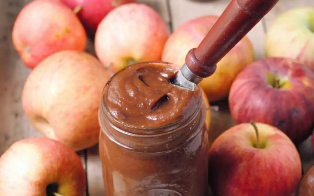 Smooth apple butter with cinnamon and cloves, presented in a mason jar