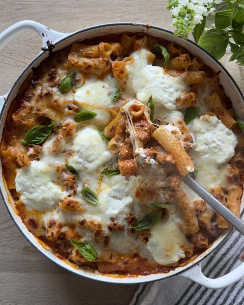 Hearty bolognese pasta bake with beef, parmesan, fresh basil, rich tomato sauce, and melted cheese.