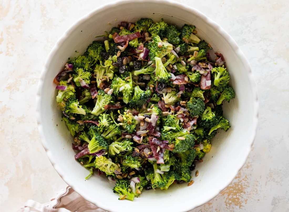 Classic broccoli salad with fresh herbs, creamy dill dressing, pumpkin seeds, dried figs, goat cheese crumbles