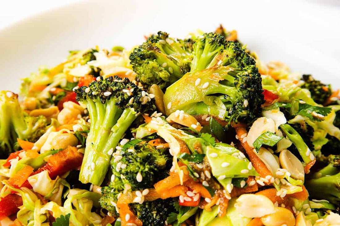 Asian broccoli salad with sesame seeds, ginger, soy sauce, toasted peanuts, and crisp carrots