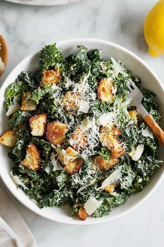 Creamy tahini kale caesar salad with sesame notes dark greens and crunchy toasted seed toppings