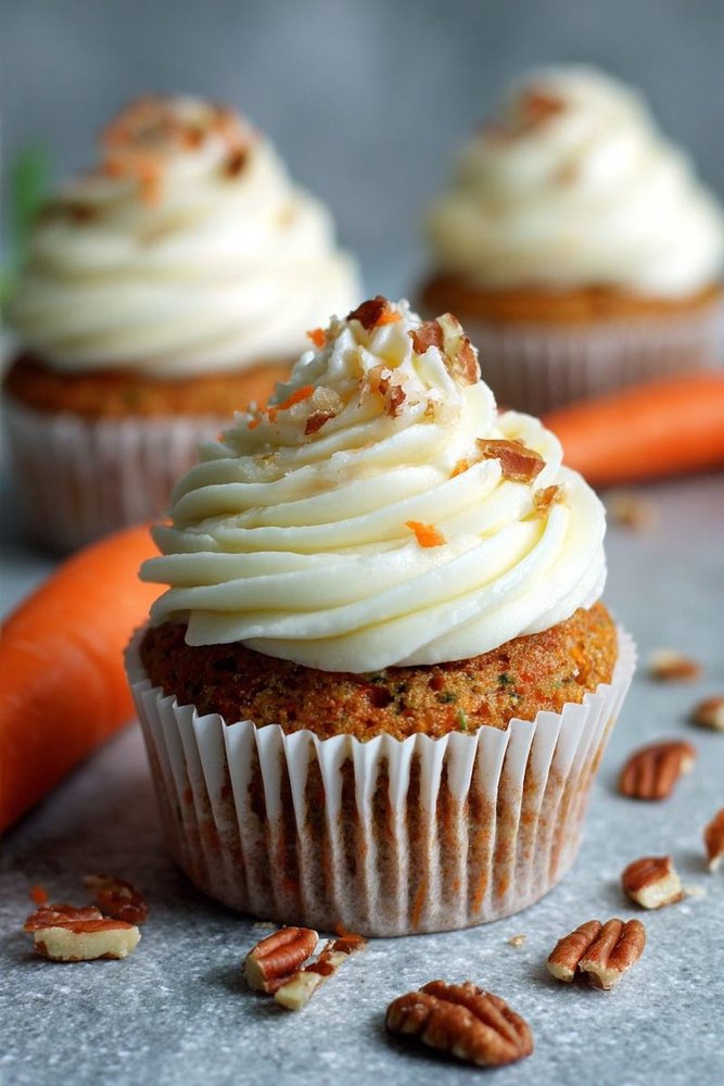 Bakery‑style carrot cupcake with thick cream cheese frosting and a dusting of powdered sugar