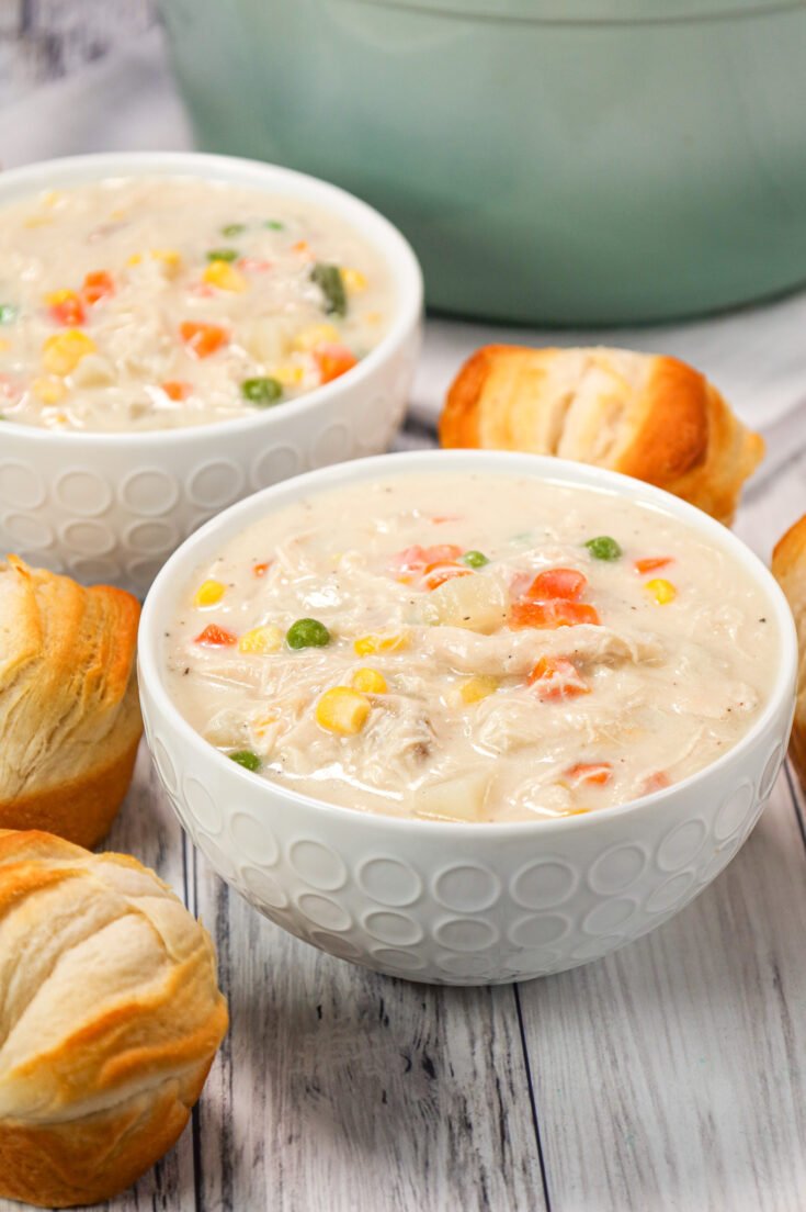 Classic creamy chicken pot pie soup with tender chicken, carrots, peas, potatoes, and a buttery biscuit topping