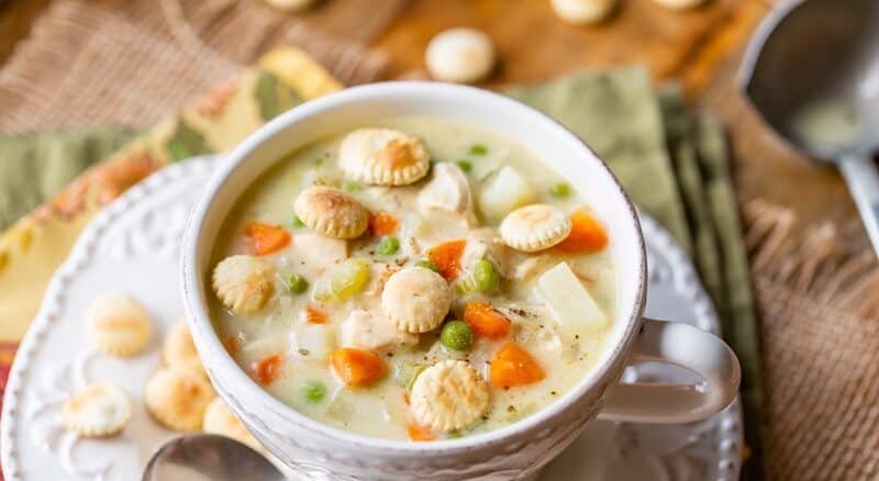 Creamy chicken pot pie soup with coconut‑lime infused broth, chicken, peas, carrots, potatoes, and biscuit topping