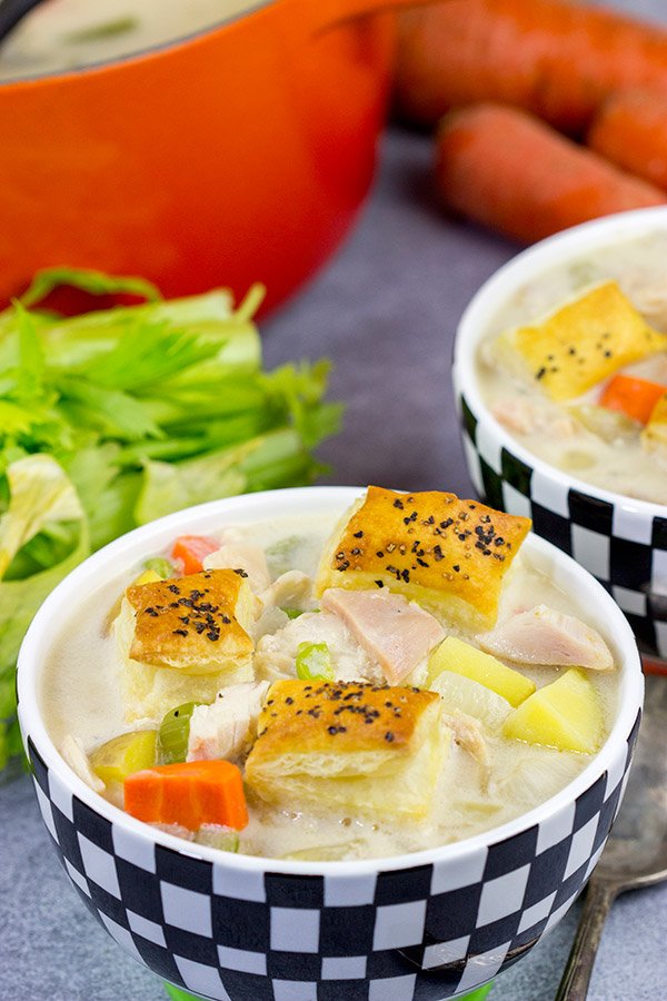 Creamy chicken pot pie soup with garlic‑infused broth, chicken, peas, carrots, potatoes, and Parmesan crumble topping
