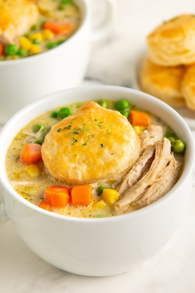 Creamy chicken pot pie soup topped with golden sweet cornbread crumble, peas, carrots, potatoes
