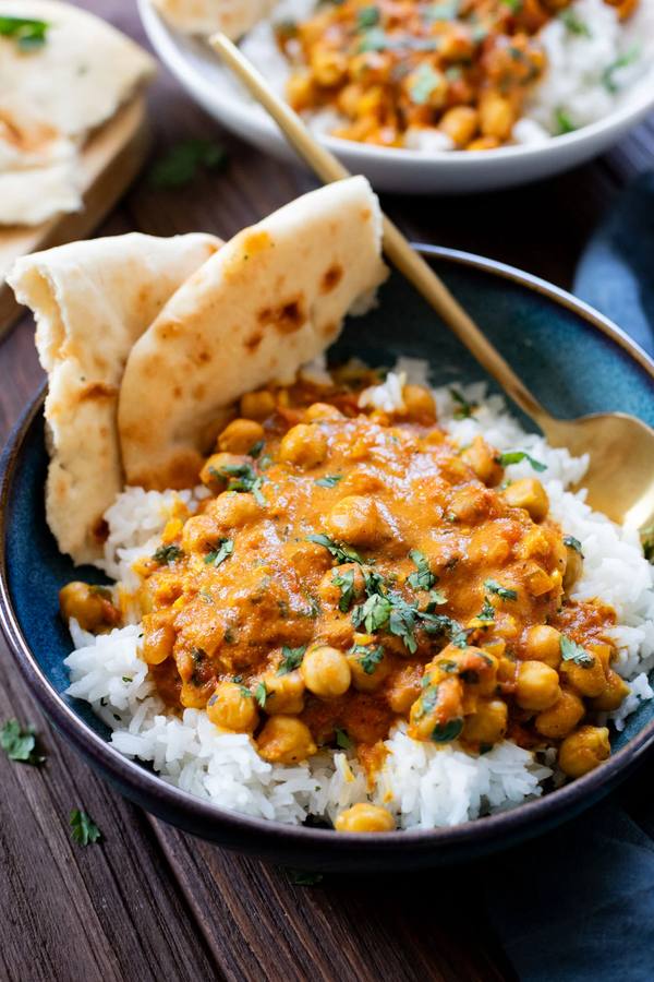 Silky coconut chickpea curry with a bright orange sauce, garnished with fresh cilantro, served over fragrant jasmine rice.