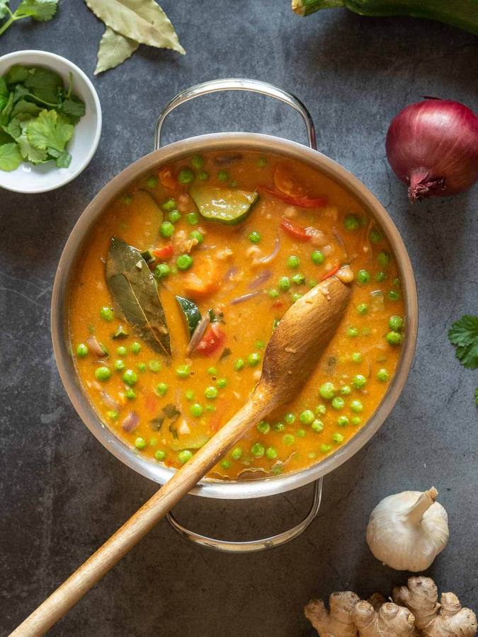 Rich coconut chickpea curry with golden sauce, aromatic spices, cilantro, served over steaming basmati rice
