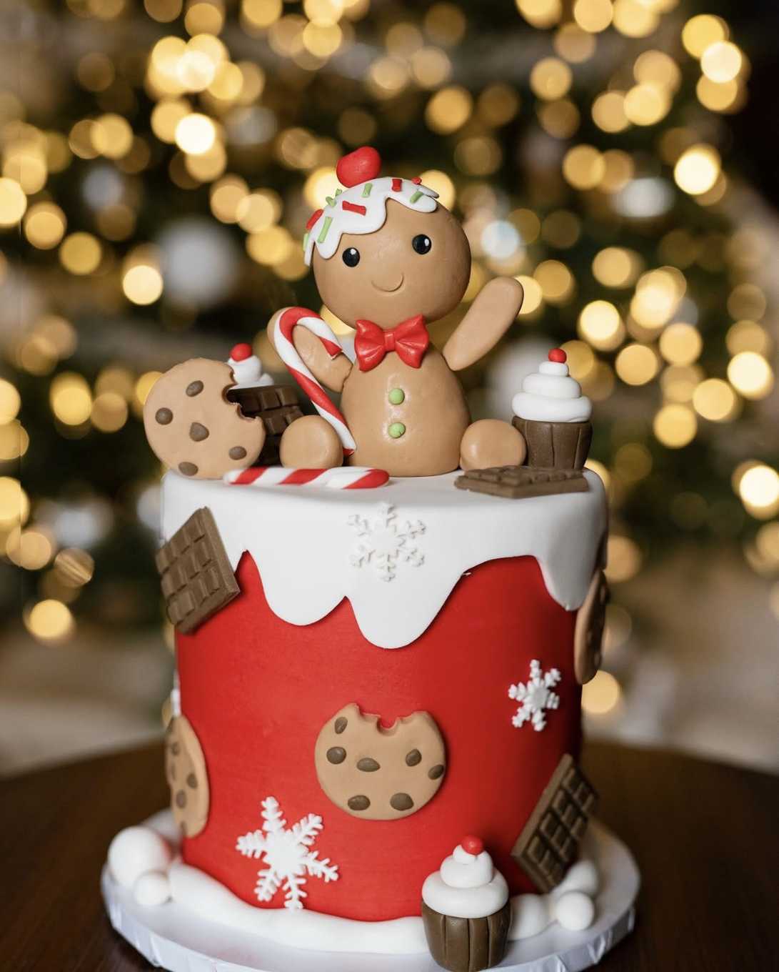 Light gingerbread cake topped with fondant‑clad gingerbread man cookies and icing details