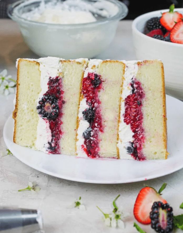 Triple‑layer vanilla cake with mixed berry compote and whipped cream frosting