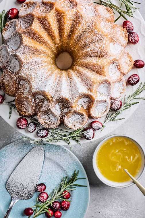 Golden bundt cake with orange zest glaze, studded with dried cranberries