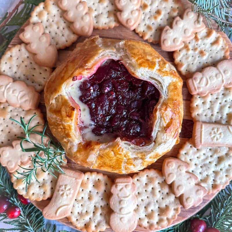Golden puff pastry encasing warm brie topped with glossy cranberry compote