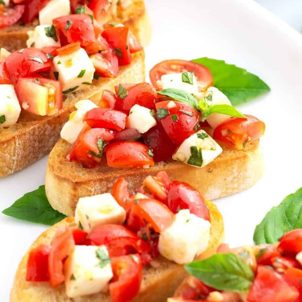 Toasted crostini topped with ripe tomatoes, mozzarella, and bright basil leaves