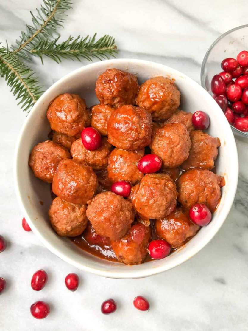 Glazed meatballs coated in a glossy cranberry cocktail sauce, served in a festive bowl