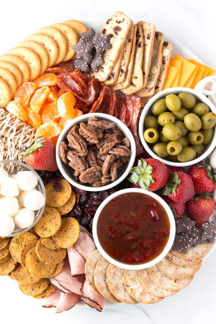 Rustic platter with spiced pecan clusters, cheese crackers, and dried fruit