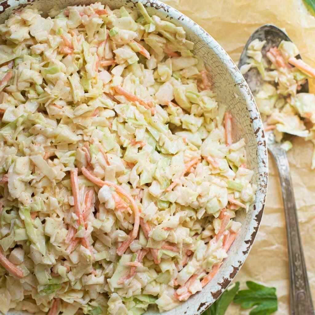 Southern creamy coleslaw with crisp cabbage, tangy pickles, and buttery mayo drizzle