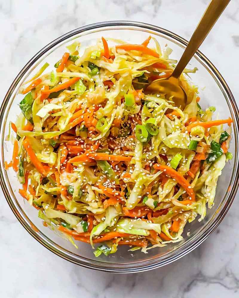 Asian sesame slaw with crisp cabbage, nutty dressing, and bright cilantro garnish
