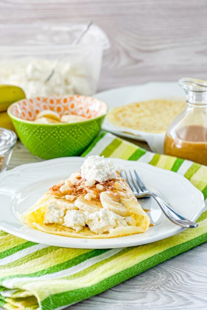 Thin golden crepes filled with caramelized bananas, topped with a drizzle of caramel and toasted almond slivers