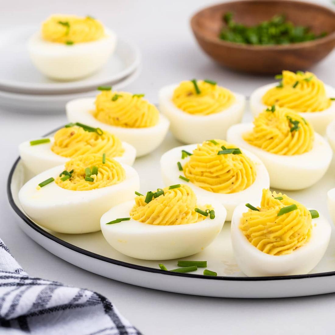Creamy yolk filling with paprika, chives, and bacon bits on hard-boiled eggs