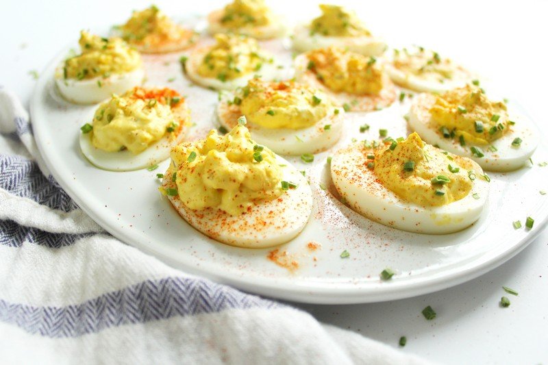 Creamy yolk filling with paprika, chives, and bacon bits on hard-boiled eggs