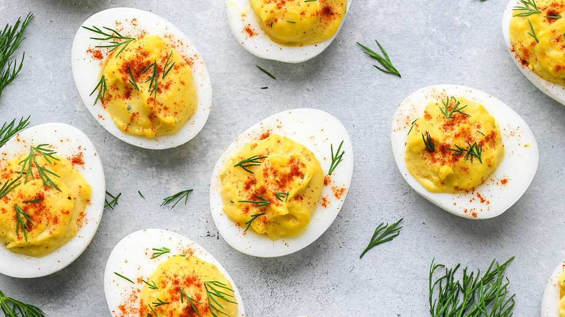 Creamy yolk filling with paprika, chives, and bacon bits on hard-boiled eggs