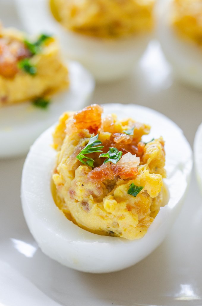 Bacon deviled eggs with creamy yolk filling, smoky bacon, paprika, and fresh chives