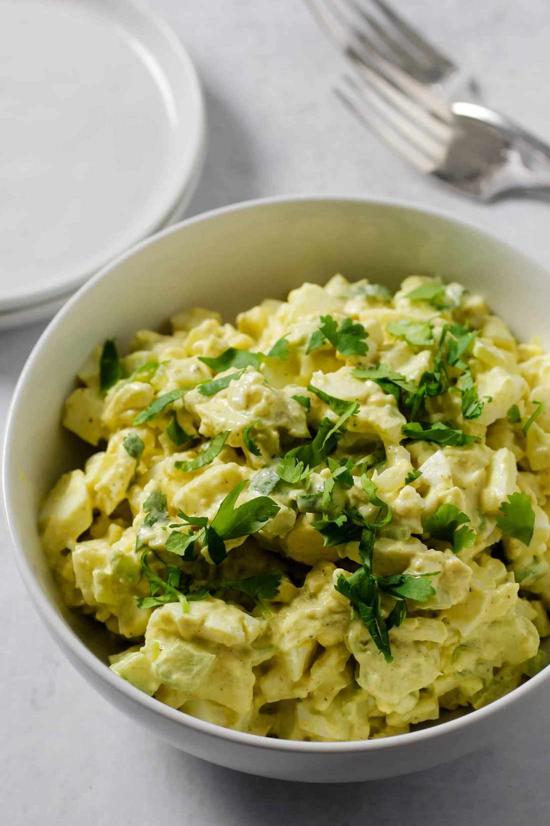 Curried egg salad with chopped eggs, creamy mayo, diced celery, and parsley garnish