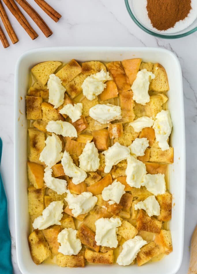 Golden custardy bread cubes topped with a silky cream cheese layer and a sprinkle of powdered sugar