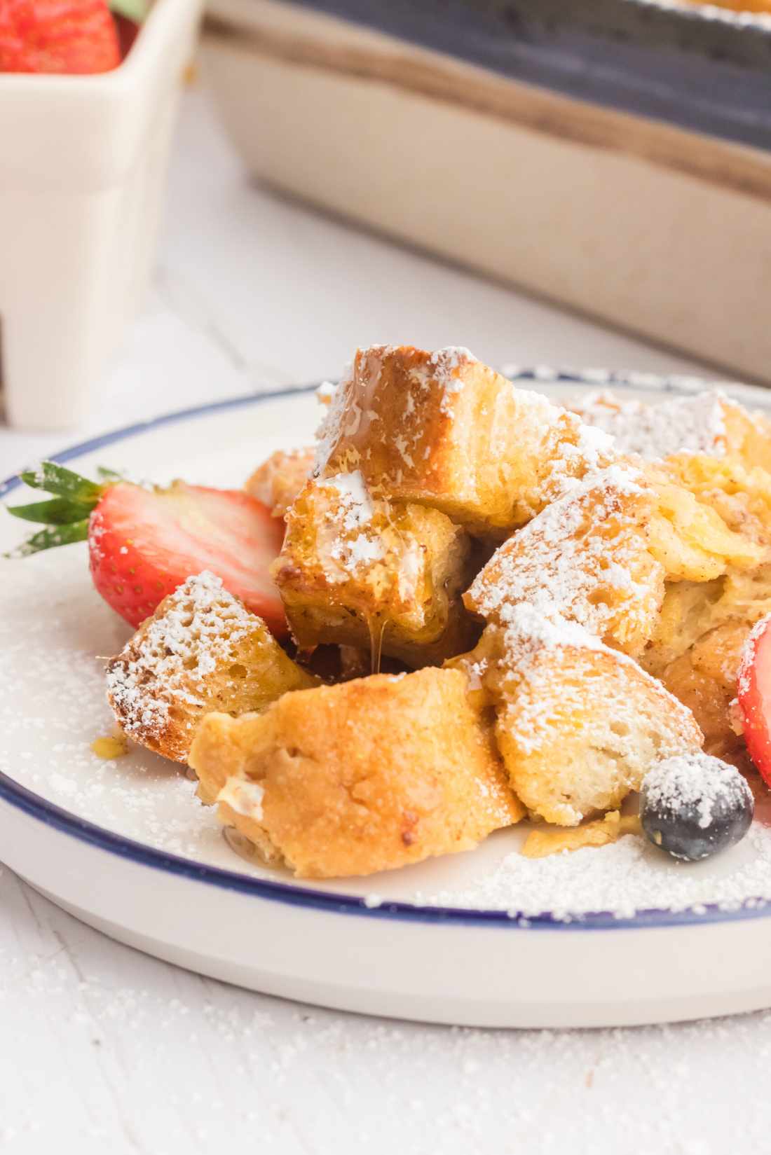 Classic French toast casserole, golden custardy bread cubes, warm berries, drizzled maple syrup