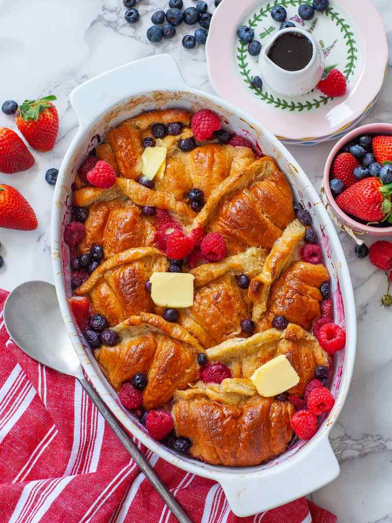 Golden croissant French toast casserole, caramelized apple chunks, warm cinnamon glaze, maple drizzle