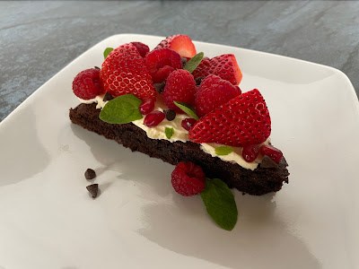 Sugar cookie crust fruit pizza topped with cream cheese frosting, fresh strawberries, kiwi, and blueberries