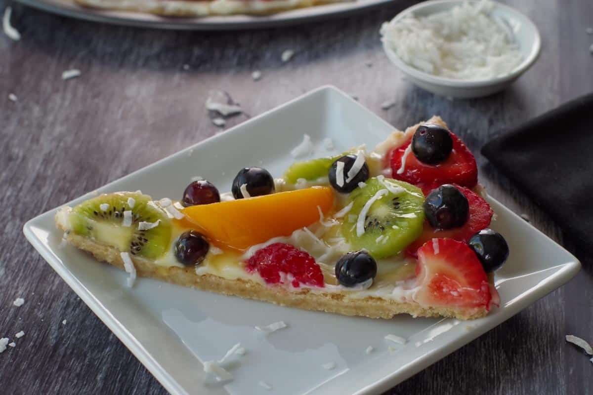 Sugar cookie base with mint-infused cream cheese frosting, fresh raspberries, blackberries, and mint leaves, refreshing fruit pizza
