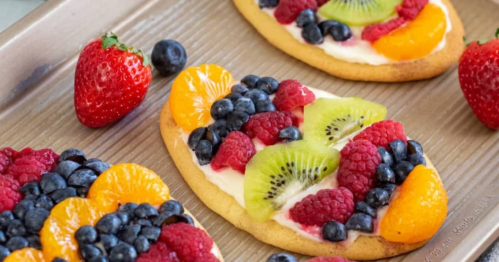Classic sugar cookie crust with vanilla cream cheese frosting, sliced kiwi, mango, and strawberries, garden fresh fruit pizza