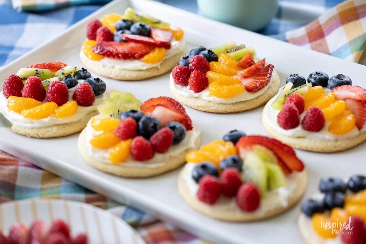 Bite‑size sugar cookie cups filled with cream cheese frosting and topped with assorted fresh fruit, mini fruit pizza cups