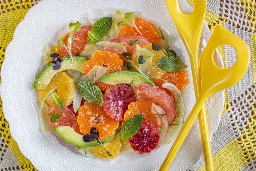 Fresh honey citrus fruit salad with juicy oranges, lemons, berries and a sweet drizzle