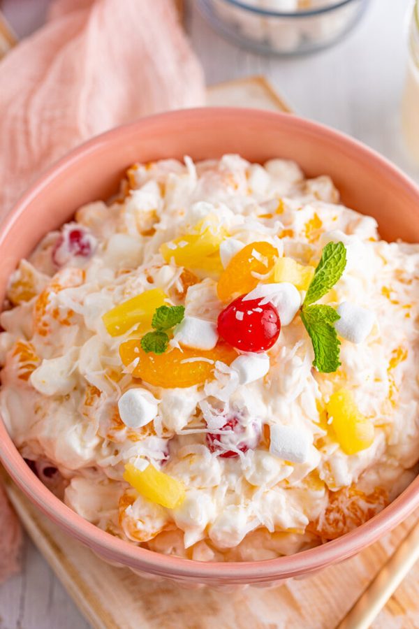 Creamy ambrosia fruit salad with coconut cream, berries, mango, and toasted almonds
