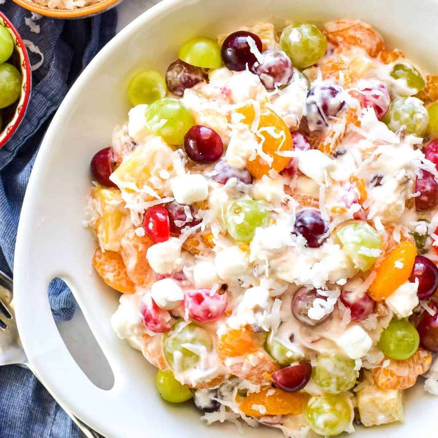 Creamy ambrosia fruit salad with avocado, berries, mango, and coconut flakes