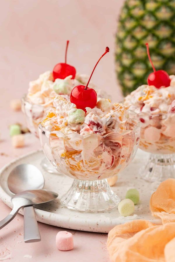 Creamy ambrosia fruit salad with juicy pineapple, mandarin, banana, and velvety vanilla dressing