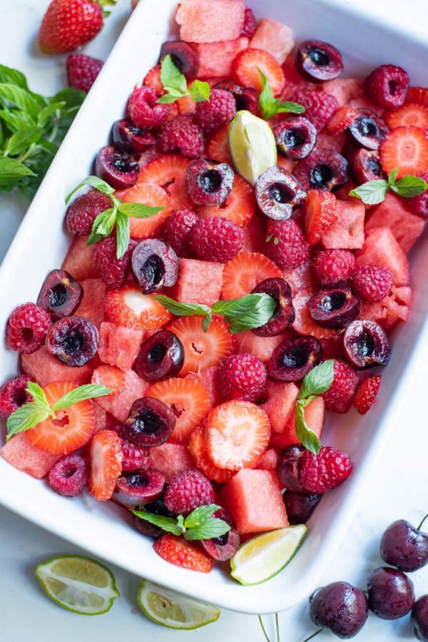 Mixed berry fruit salad with strawberries, blueberries, raspberries, and a citrus‑honey drizzle