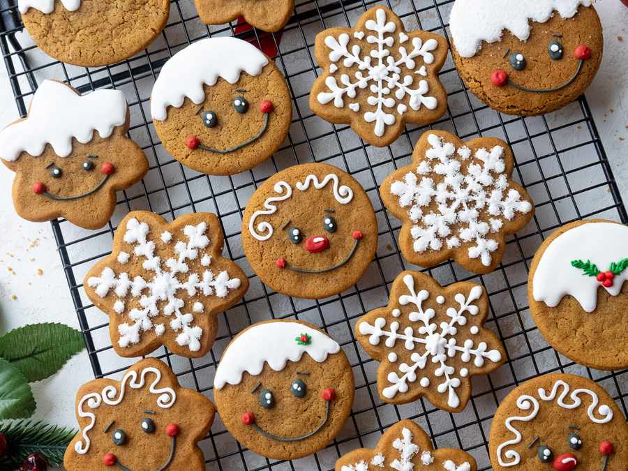 Iced gingerbread snowflakes and round cookies with snowy icing, warm spices, festive charm