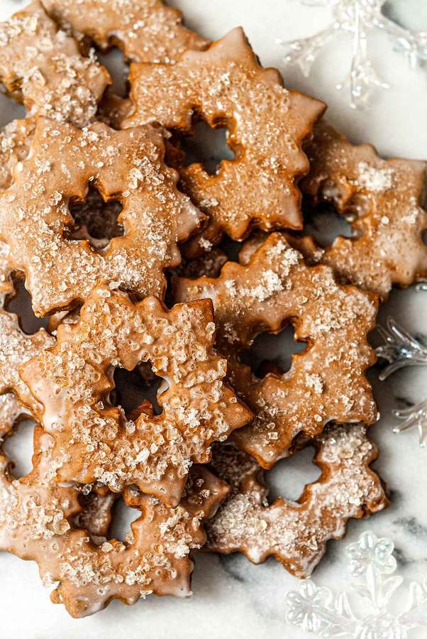 Star-shaped gingerbread cookies glazed with sweet icing and sprinkled coarse sugar, warm spices
