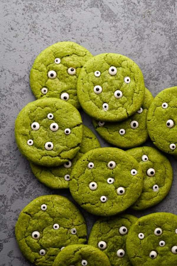 Bright green sugar cookies with white frosting, topped with red candy “blood” and chocolate “pupils.”