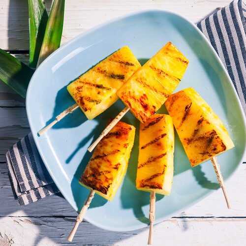 grilled pineapple skewers with crisp broccoli florets, nuts, dried fruit, cheese, and savory dressing
