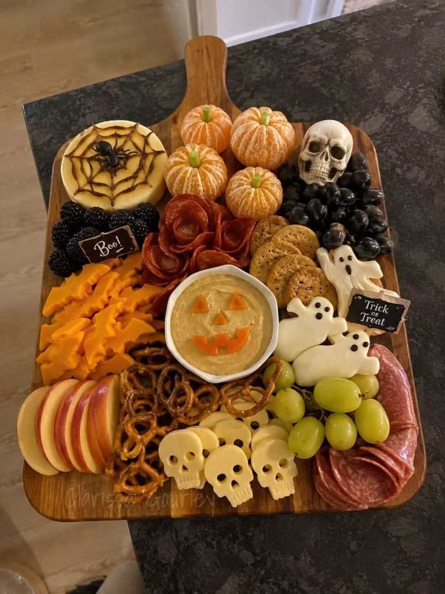A lavish charcuterie board with cheese skulls, cured meats, and seasonal fruits.