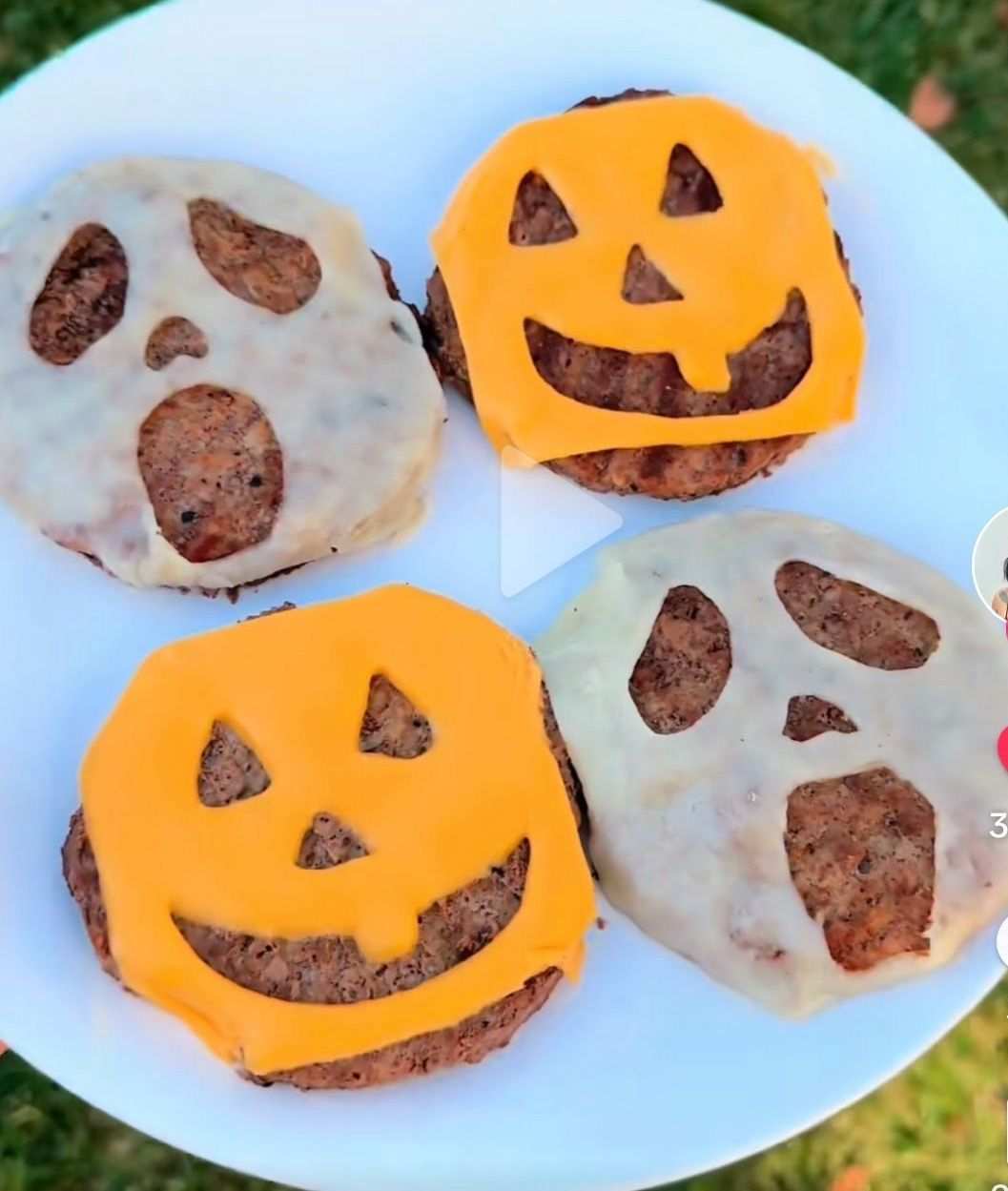 Shaped beef burger patties in the form of ghosts and pumpkins grilled on a skillet