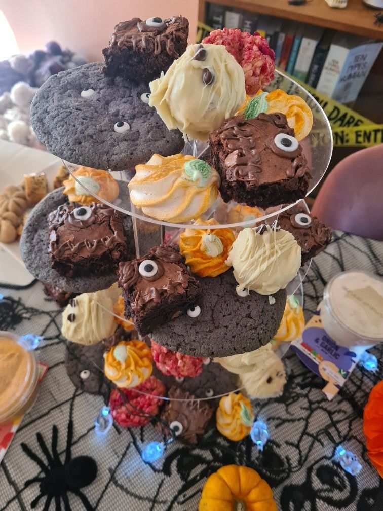 Chunky monster cookies with green and purple candies on a tiered pastry stand