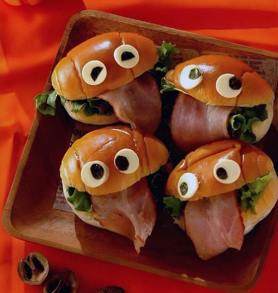 Open-faced sandwiches with ham, cheese, and a strawberry slice tongue on a plate
