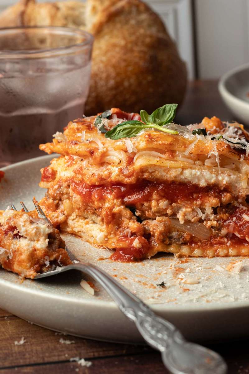 Spinach ravioli lasagna layered with tomato sauce, ricotta, and melted mozzarella cheese