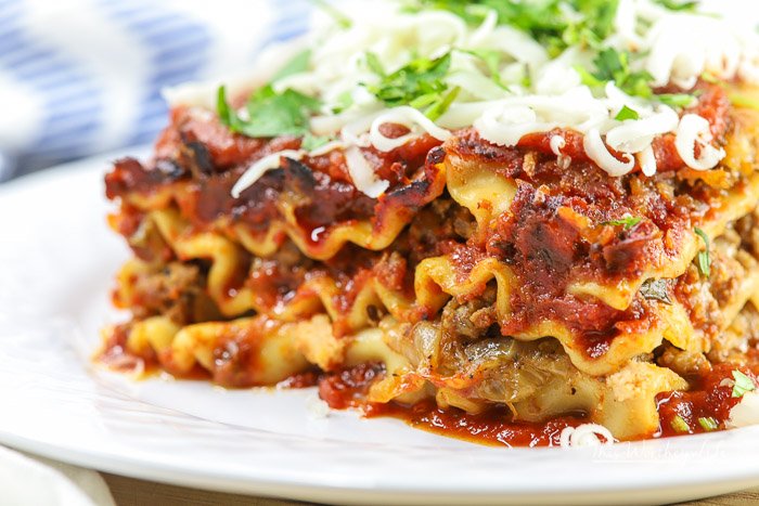 Lush green spinach‑ricotta lasagna layers with bubbling golden mozzarella and rich tomato sauce