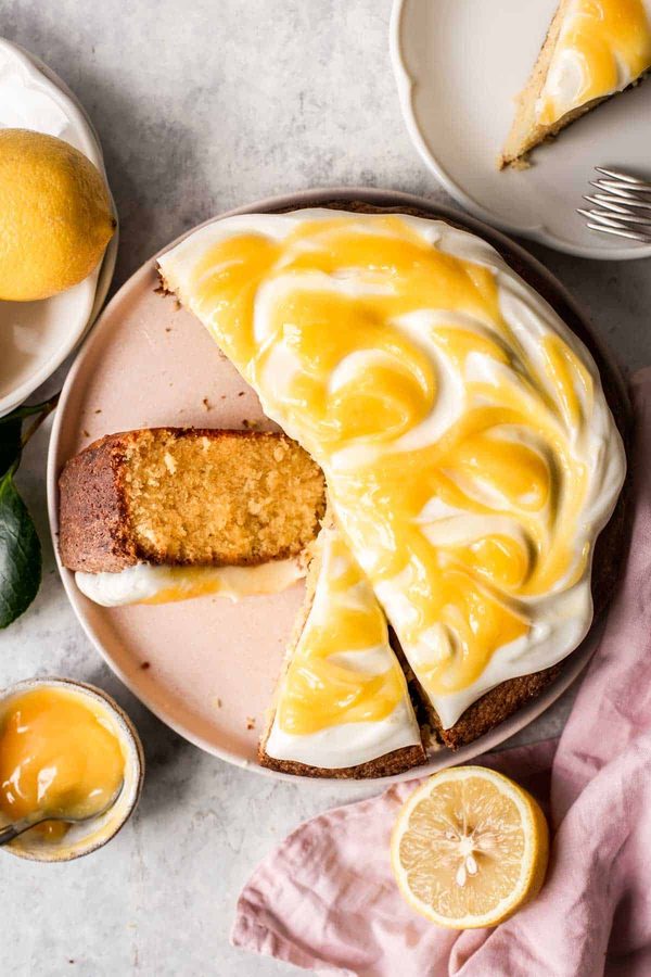 Moist lemon cake drizzled with lemon curd glaze, bright citrus, topped with fresh berries